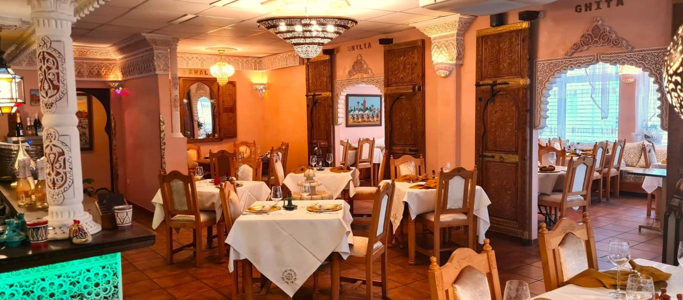 Innenraum des marokkanischen Bio-Restaurants BIODuMAROC in Augsburg mit orientalischen Stuckverzierungen, Kronleuchtern und festlich gedeckten Tischen